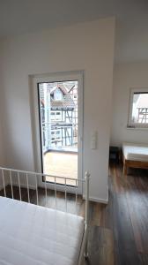 Habitación blanca con cama y ventana en NEU! FeWo Marburg 2 mit Balkon, 