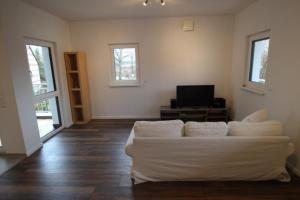 a living room with a white couch and a television at Neu! FeWo Lahnblick 1 