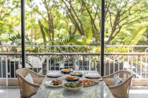una mesa con tazones de comida en el balcón en The Park Nine Hotel Srinakarin en Bangkok