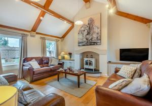 uma sala de estar com mobiliário de couro e uma televisão em Captains Cottage em Thornham