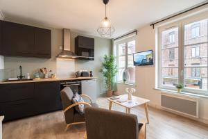 a kitchen and living room with a table and chairs at Hypercentre - 2 pièces confortable in Lille