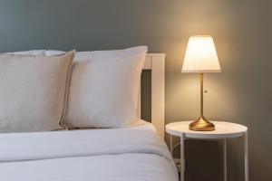 a white bed with a lamp on a side table at Hypercentre - 2 pièces confortable in Lille