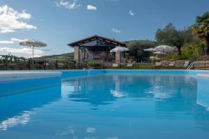 a swimming pool with blue water in front of a building at Tenuta di Caiolo in Panicale