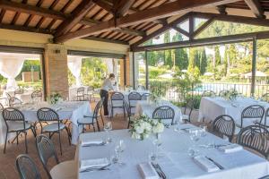 a woman sitting at a table in a room with white tables at Tenuta di Caiolo in Panicale