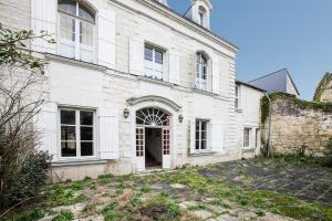una vista exterior de un edificio blanco con una puerta en La Belonnerie - Grande maison pour 13, en Varrains