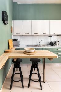uma cozinha com uma mesa de madeira e 2 bancos de bar em Margarita by halu!, 3-BD tropical house em Tessalônica