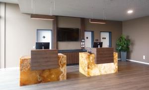 an office lobby with two reception desks and a flat screen tv at Tools Hotel Laichingen in Laichingen