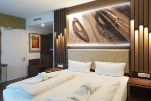 una camera da letto con un grande letto con un'immagine appesa alla parete di Tools Hotel Laichingen a Laichingen