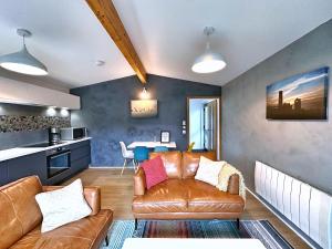 a living room with a couch and a table at Chy Cos. South facing lodge with balcony & views. in St. Agnes  +20 photos