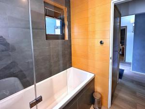 a bathroom with a tub and a glass shower at Chy Cos. South facing lodge with balcony & views. in St. Agnes