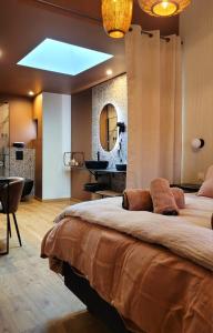 a bedroom with a large bed and a bathroom at Tresors de Sens in Sens