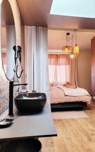 łazienka z czarną umywalką i łóżkiem w obiekcie Tresors de Sens w mieście Sens
