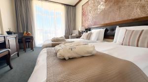 a hotel room with two beds with white sheets at Platinum Hotel and Casino Bansko in Bansko