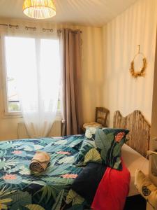 a bedroom with a bed with a colorful blanket at Maison paisible in Niort