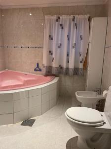uma casa de banho com uma banheira rosa, um WC e um lavatório. em Fritidsbolig i Flå sentrum em Fla