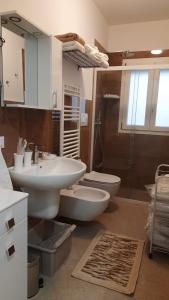 een badkamer met 2 wastafels, een toilet en een douche bij NOTE DI MARE in Mola di Bari
