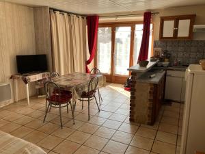 a kitchen with a table and chairs and a kitchen with a refrigerator at Le Mont Dore Résidence Cottage rez de chausse in Le Mont-Dore