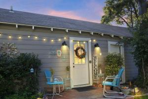 una casa con 2 sillas y una puerta con luces en The Coziest Cottage in Waxahachie, en Waxahachie