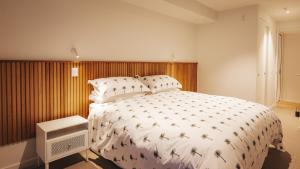 a bedroom with a large white bed with palm trees on it at Beautiful urban apartment 5 in Nelson