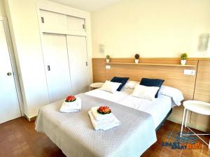 Habitación de hotel con 2 camas, toallas y flores. en APARTBEACH SOL y PLAYA 245 CLIMATIZADO VISTAS PISCINA, en Salou