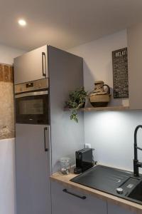 a kitchen with a refrigerator and a sink and a counter at Rustikal wohnen in Renningen in Renningen