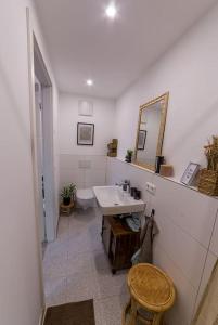 a white bathroom with a sink and a mirror at Rustikal wohnen in Renningen in Renningen