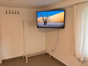uma televisão de ecrã plano numa parede num quarto em db-rooms-b em Kassel