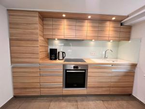uma cozinha com armários de madeira e um lavatório em db-rooms-b em Kassel