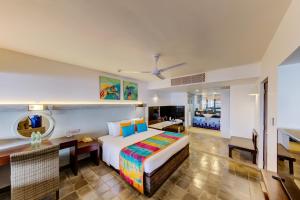 a hotel room with a bed and a desk and a room at Hikka Tranz by Cinnamon in Hikkaduwa +37 photos