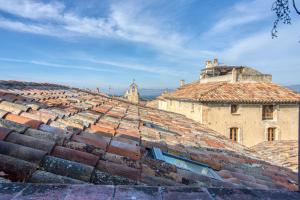 una vista aérea de los tejados de un edificio antiguo en Hôtel Restaurant Les Remparts, en Venasque