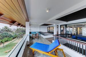 a balcony with a blue chair and a table at Hikka Tranz by Cinnamon in Hikkaduwa