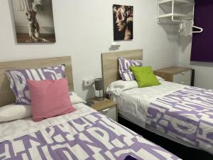 2 camas en una habitación de color púrpura y verde en Albahicín, en Puerto Sagunto