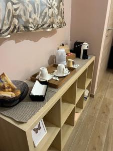 une table avec des assiettes et de la vaisselle en haut dans l'établissement Buongiorno & Benvenuti, à Trani