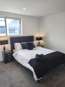 a bedroom with a large bed and two lamps and a window at Stylish Townhouse in City Centre in Christchurch