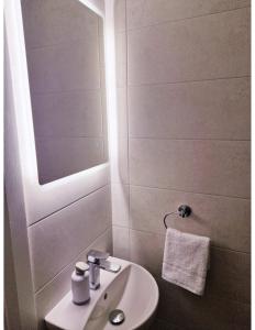 a white bathroom with a sink and a mirror at Station Lodge in Sligo