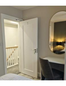 een slaapkamer met een spiegel en een bureau met een stoel bij Station Lodge in Sligo