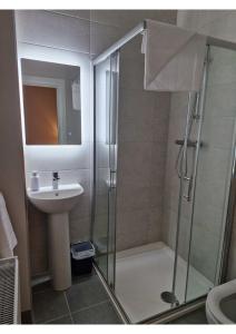 een badkamer met een douche en een wastafel bij Station Lodge in Sligo