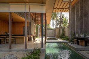 - une vue sur l'extérieur d'une maison avec une piscine dans l'établissement Rumah Amadangi, à Tanah Lot