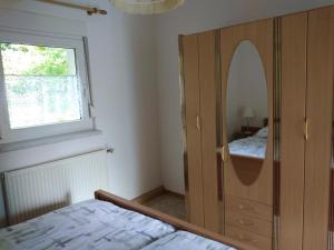 um quarto com um grande armário de madeira com um espelho em NEU! See-Ferienwohnung 2 em Großmöhlau