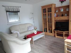 a living room with a white couch and a tv at NEU! See-Ferienwohnung 1 in Großmöhlau