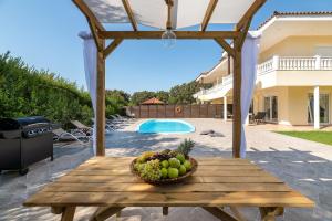 a wooden table with a bowl of fruit on it at Villa Montefile in Ialysos