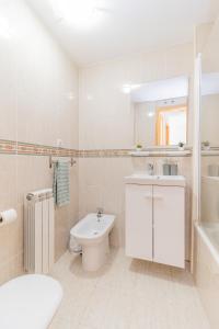 a white bathroom with a sink and a toilet at Los Pinos, acogedor apartamento con garaje - Arafita Apartamentos in Sabiñánigo +37 photos