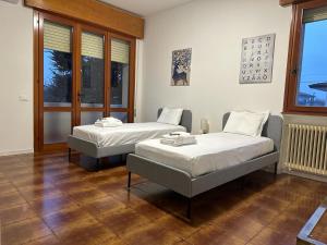 2 Betten in einem Zimmer mit 2 Fenstern in der Unterkunft Welc-ōM Caselle 