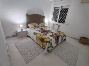 um quarto com uma cama, 2 candeeiros e uma janela em Appartement Cozy aux Berges du Lac 1 em Tunes