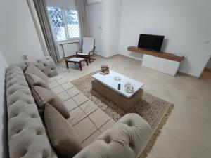 uma sala de estar com um sofá grande e uma mesa em Appartement Cozy aux Berges du Lac 1 em Tunes