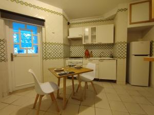 Appartement Cozy aux Berges du Lac 1 في تونس: مطبخ مع طاولة وكراسي وثلاجة