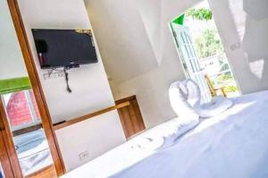 a room with a bed with a tv and a mirror at Kanda Hill Resort in Ban Na Sok