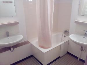 a white bathroom with a tub and a sink at Cap Verb Guillestre in Guillestre