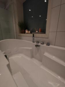 a white bath tub in a bathroom with a mirror at Andenes Sentrum Apartment in Andenes