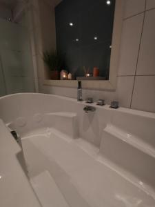 a white bath tub in a bathroom with a mirror at Andenes Sentrum Apartment in Andenes +28 photos